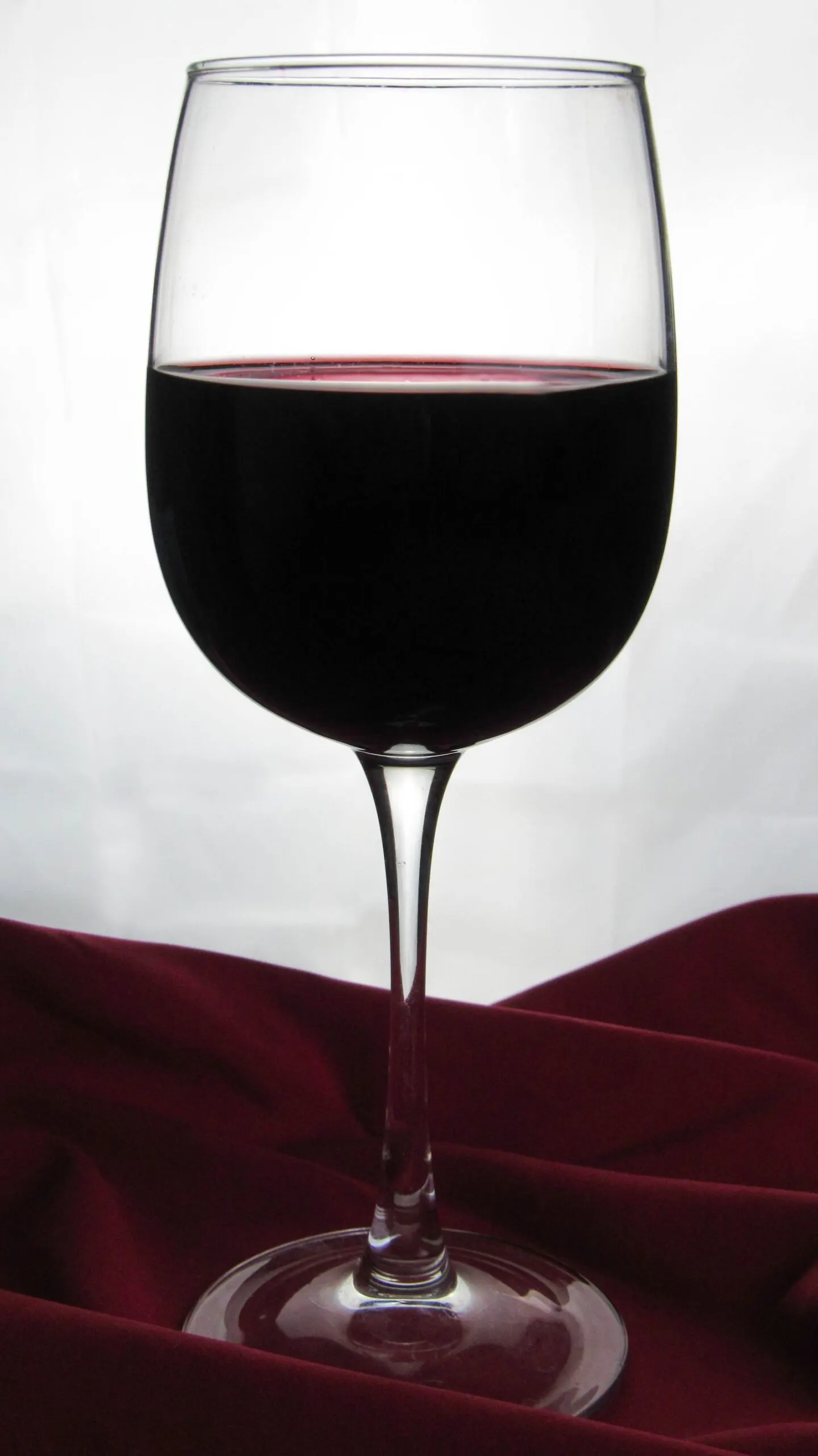 Copa de vino tinto en primer plano para apreciar color y lagrimas, fondo neutro